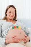 Portrait of a future mom with baby letters on her belly