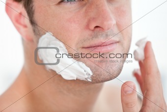 Close-up of a cute man preparing to shave in the bathroom