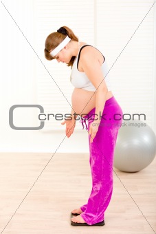 Indignant beautiful pregnant woman measuring her weight
