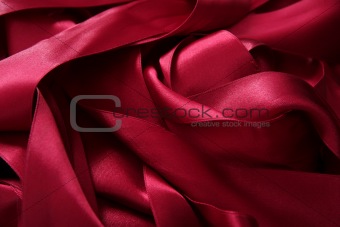 Red satin ribbons in a messy mess texture