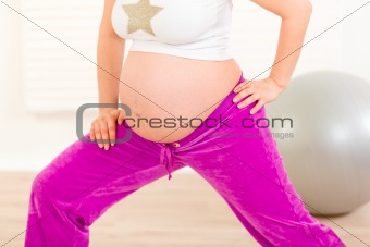 Pregnant woman doing stretching exercises at home.  Close-up.
