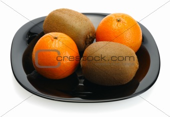 Kiwi and mandarin on a black plate