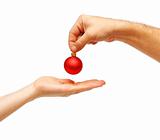 male hands give a christmas ball to female hands