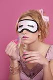 blond woman smelling perfume sleep mask blind