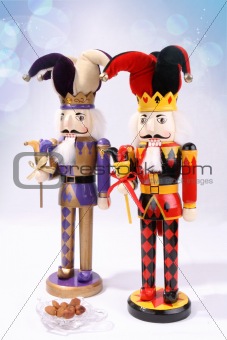 Two wooden nutcrackers with a plate of nuts