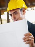 architect with blueprint in construction site