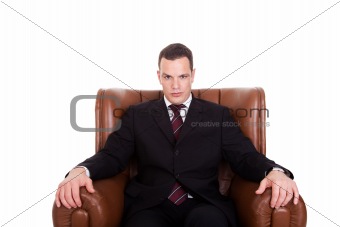 Businessman seated on a chair, isolated on white background. Studio shot.