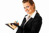 Smiling modern business woman making notes in document
