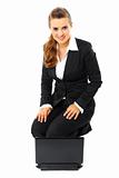 Smiling modern business woman sitting on  floor with laptop
