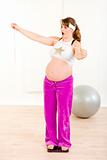 Shocked pregnant woman standing on weight scale and holding  measure tape
