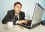 Businessman drinks coffee through a straw and work in Internet