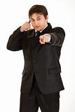 Smiling young businessman showing contact me gesture
