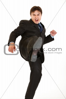 Very angry young businessman hard  kicking
