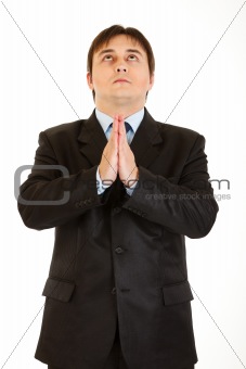 Young businessman praying for success
