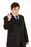 Strict young  businessman shaking his finger
