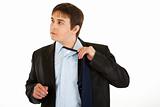 Tired young businessman untying his tie 
