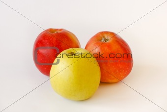two red and one green apples on white background