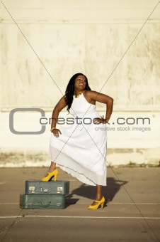 African American woman with suitcases laughs