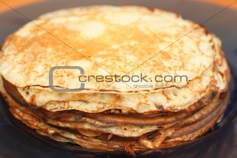 Many pancakes lay in a plate