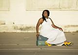 African American woman sitting on suitcases