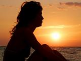 Young girl dreaming on sunset background
