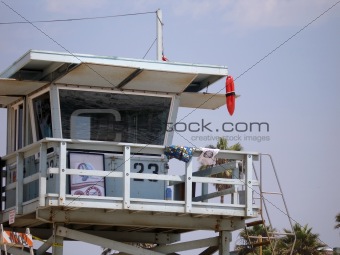 Lifeguard house with hanging float against blue sky