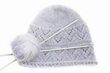 Grey woolen knitted mohair cap with clew and knitting needles