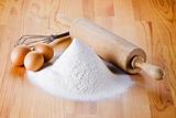 Flour with eggs, rolling pin and beater