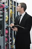 businessman withnotebook in network server room