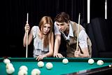 The young couple plays billiards