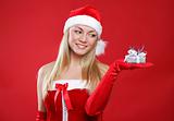 Young beautiful girl dressed as Santa holds a small gift in their hand.
