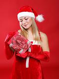 Young beautiful girl dressed as Santa holds a gift in their hands.
