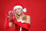 Young beautiful girl dressed as Santa holds a gift in their hands.