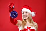 A young girl dressed as Santa Claus on a red background holds a 