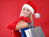 Portrait of a young charming girl dressed as Santa with a bag of shopping in their hands