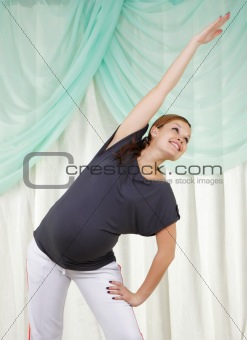 Young pregnant woman doing exercises 