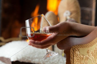 Resting at the burning fireplace fire with a glass of cognac