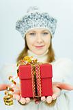 girl in winter hat gives gift box
