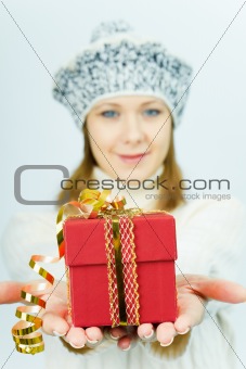 girl in winter hat gives gift box