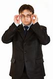 Modern businessman straightening eyeglasses
