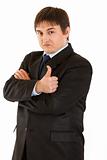 Confident young businessman showing  thumb up gesture. Concept - confidence and reliability
