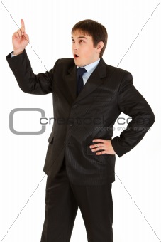 Surprised young businessman with rised finger. Idea gesture.
