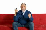 old man on the sofa with television remote control