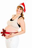 Happy beautiful pregnant woman in Santa hat with  red ribbon on belly
