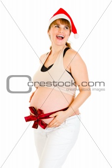 Happy christmas pregnant woman in Santa hat with  red ribbon on belly
