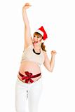 Happy christmas pregnant woman in Santa hat showing  thumb up gesture 
