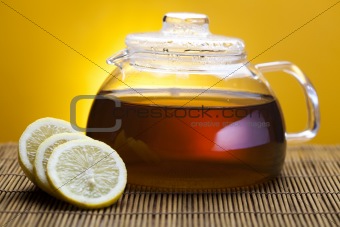 Glass teapot of tea with lemon