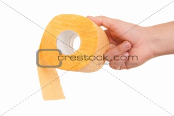 Hand holds roll of yellow toilet paper