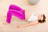 Smiling beautiful pregnant female doing fitness exercises at home
