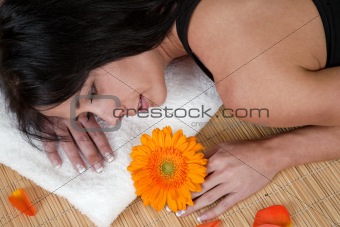 Woman lying on bamboo mat at spa